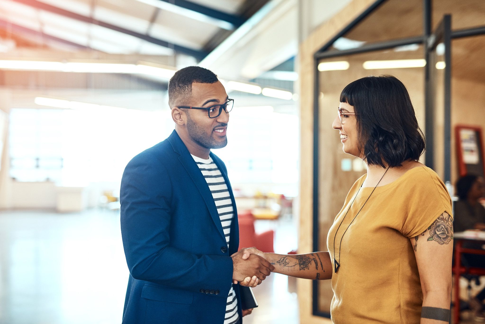 man and woman shaking hands in office setting