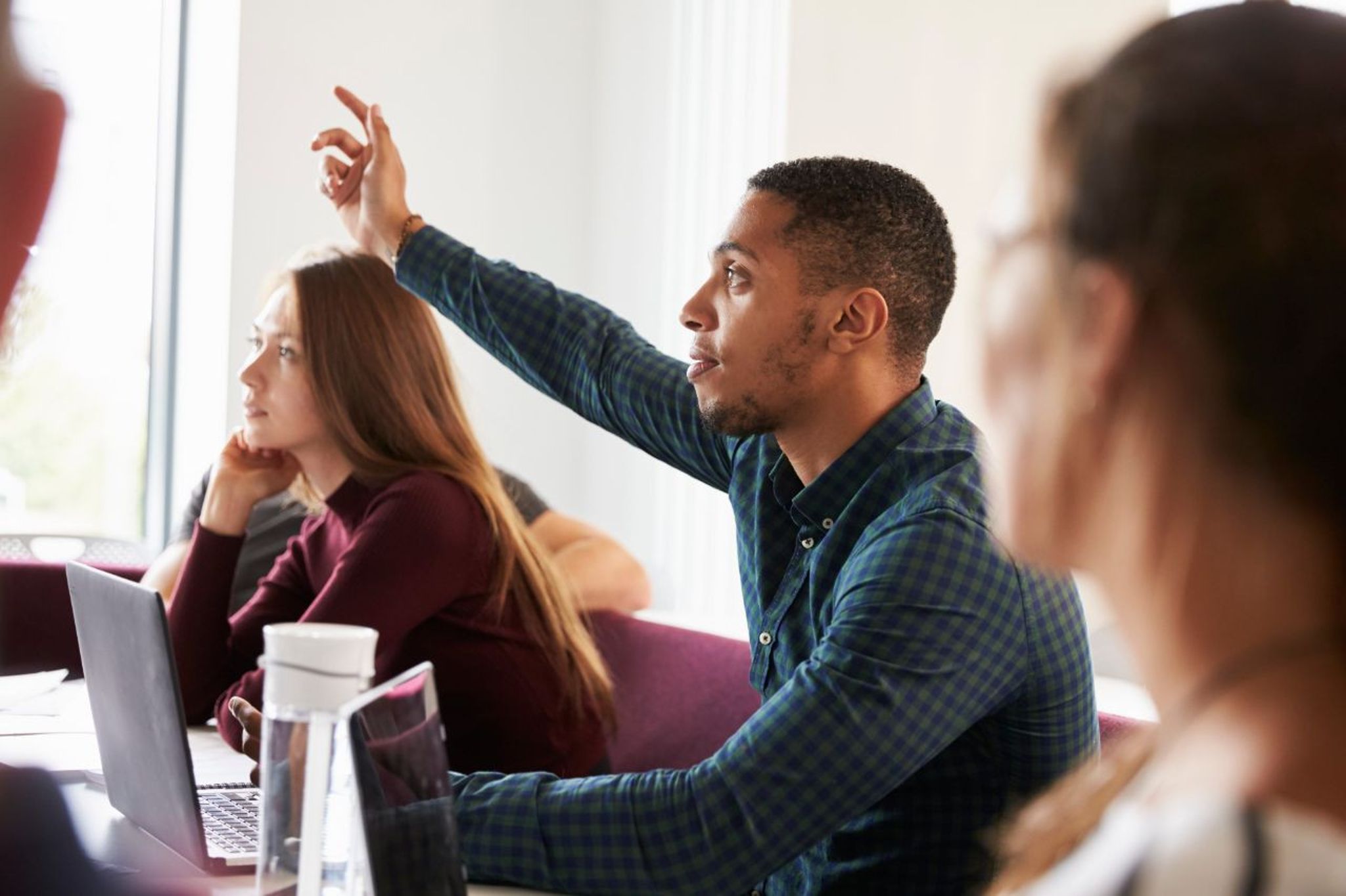 student raising hand in class