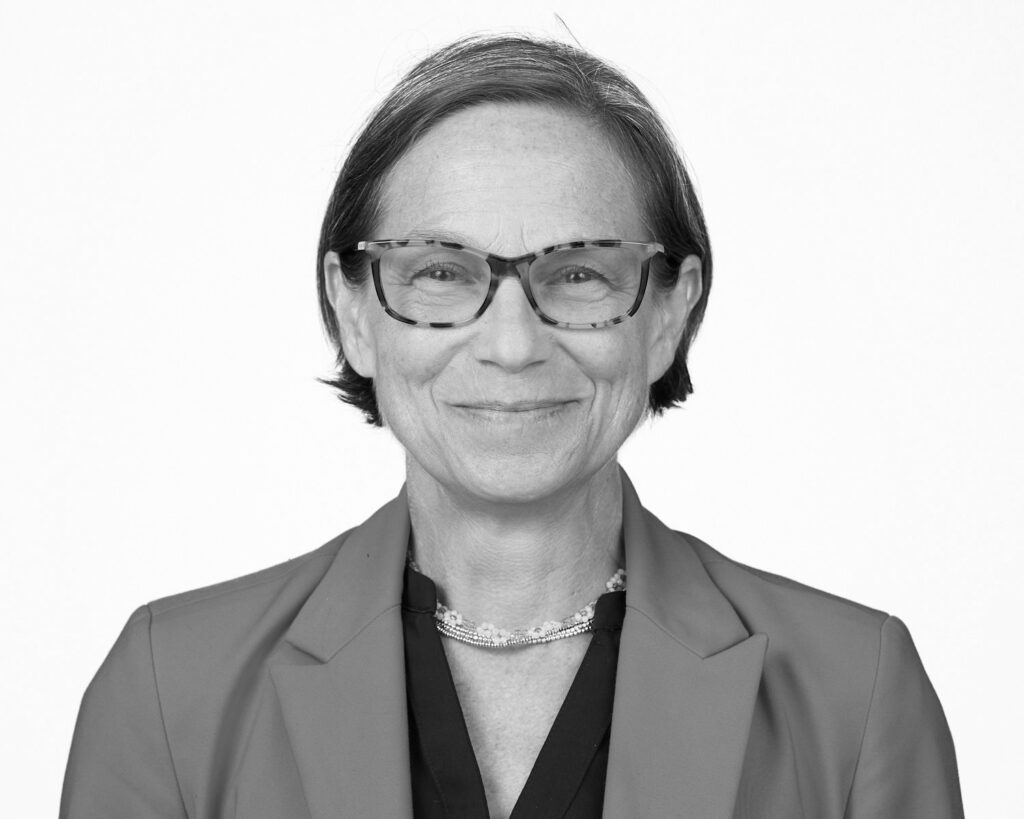 Headshot of A woman wearing glasses and a suit