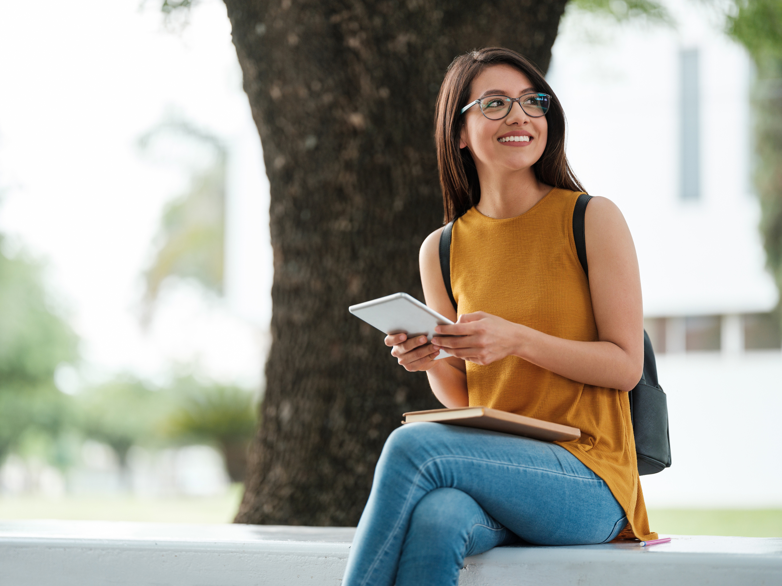 woman holding tablet sitting on ledge