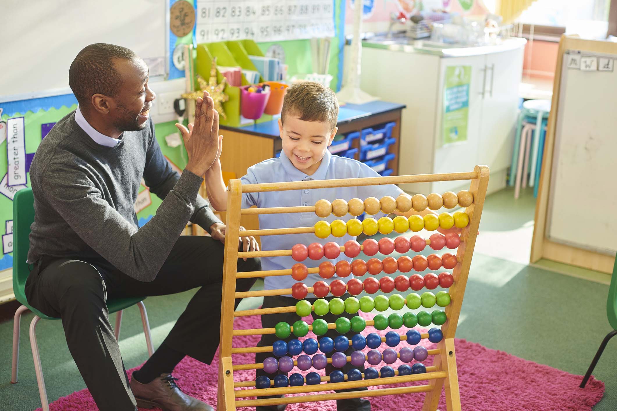 male kindergarten teacher high-fiving student