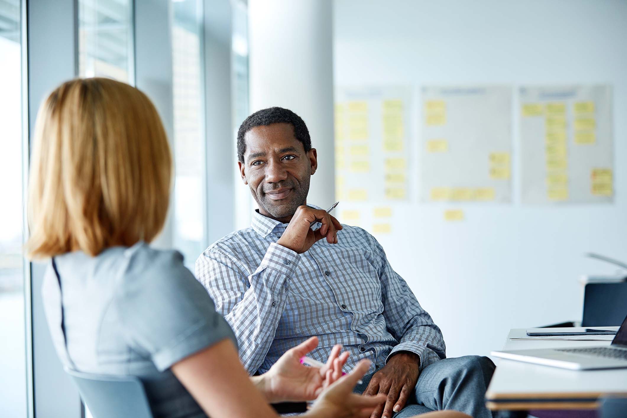 man talking with woman at a desk