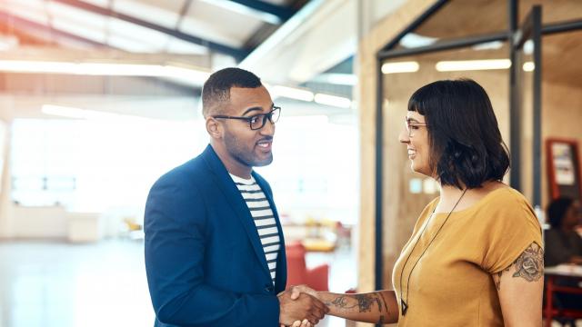 man and woman shaking hands in one of the business administration graduate programs
