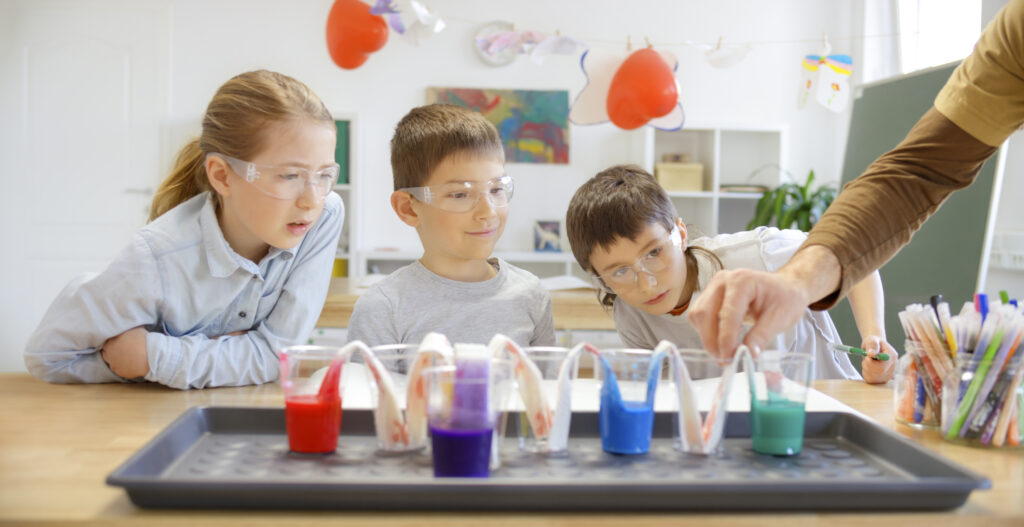 children doing science project under guidance of teacher with multiple subject teaching credential