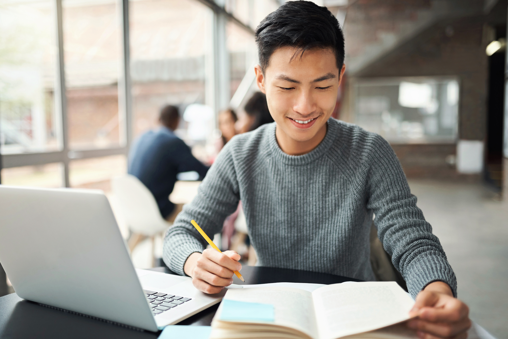 person looking at his laptop and paper