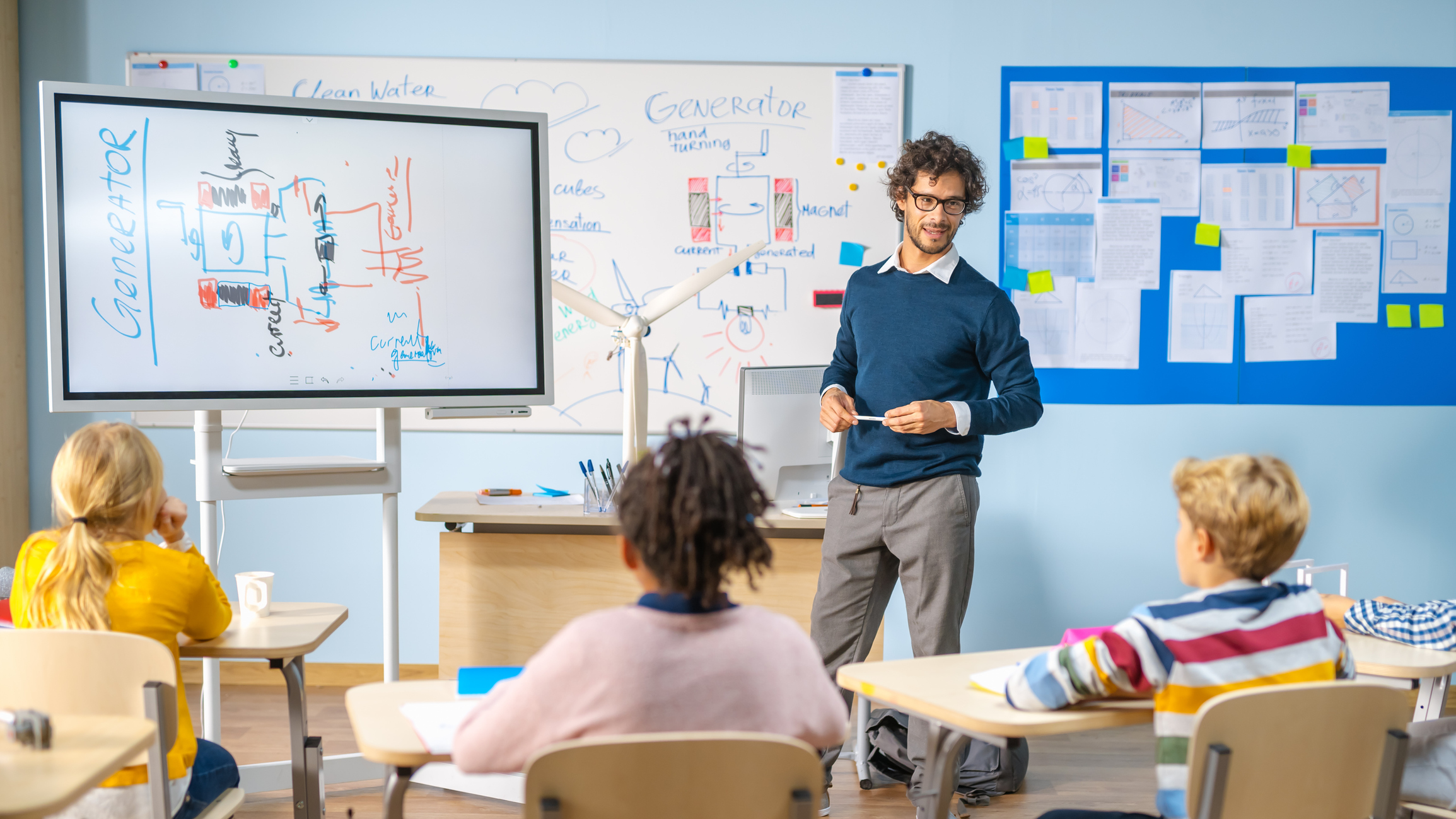 male teacher teaching students with boards