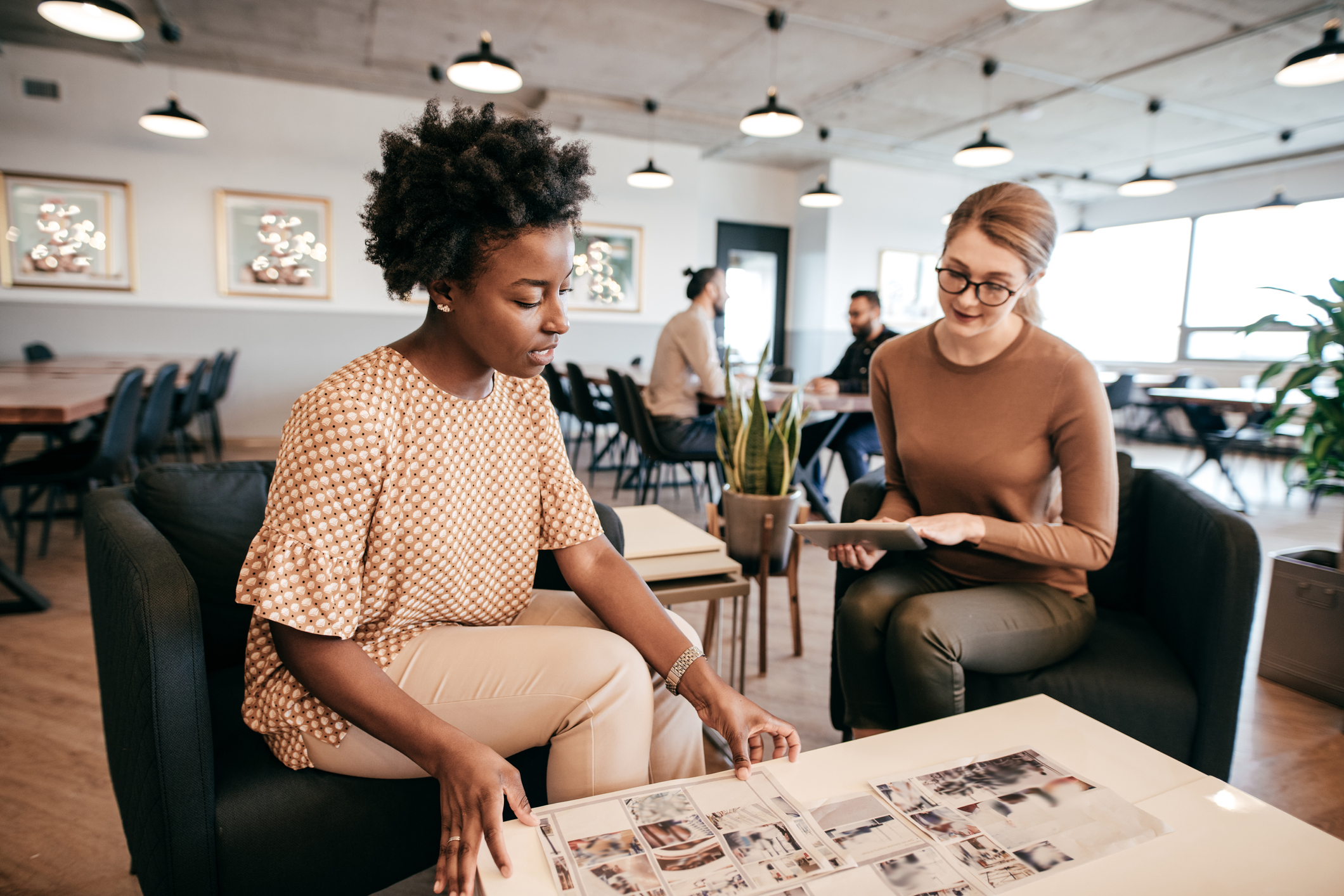woman talking to woman while pointing at table