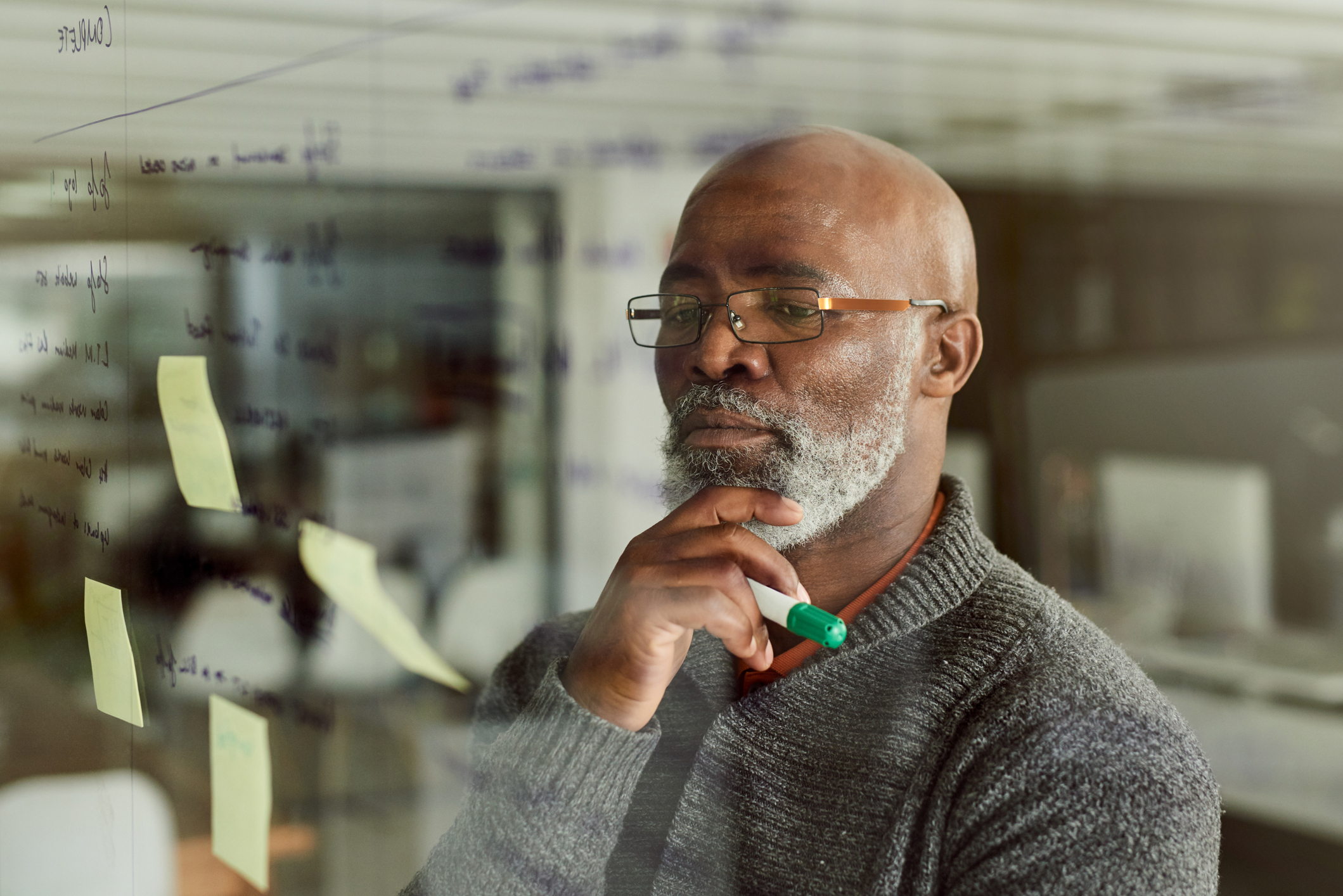 man thinking and looking at post it