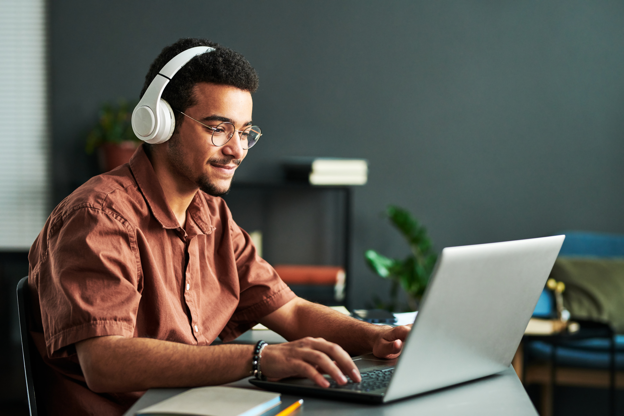 man with headphone looking at a laptop