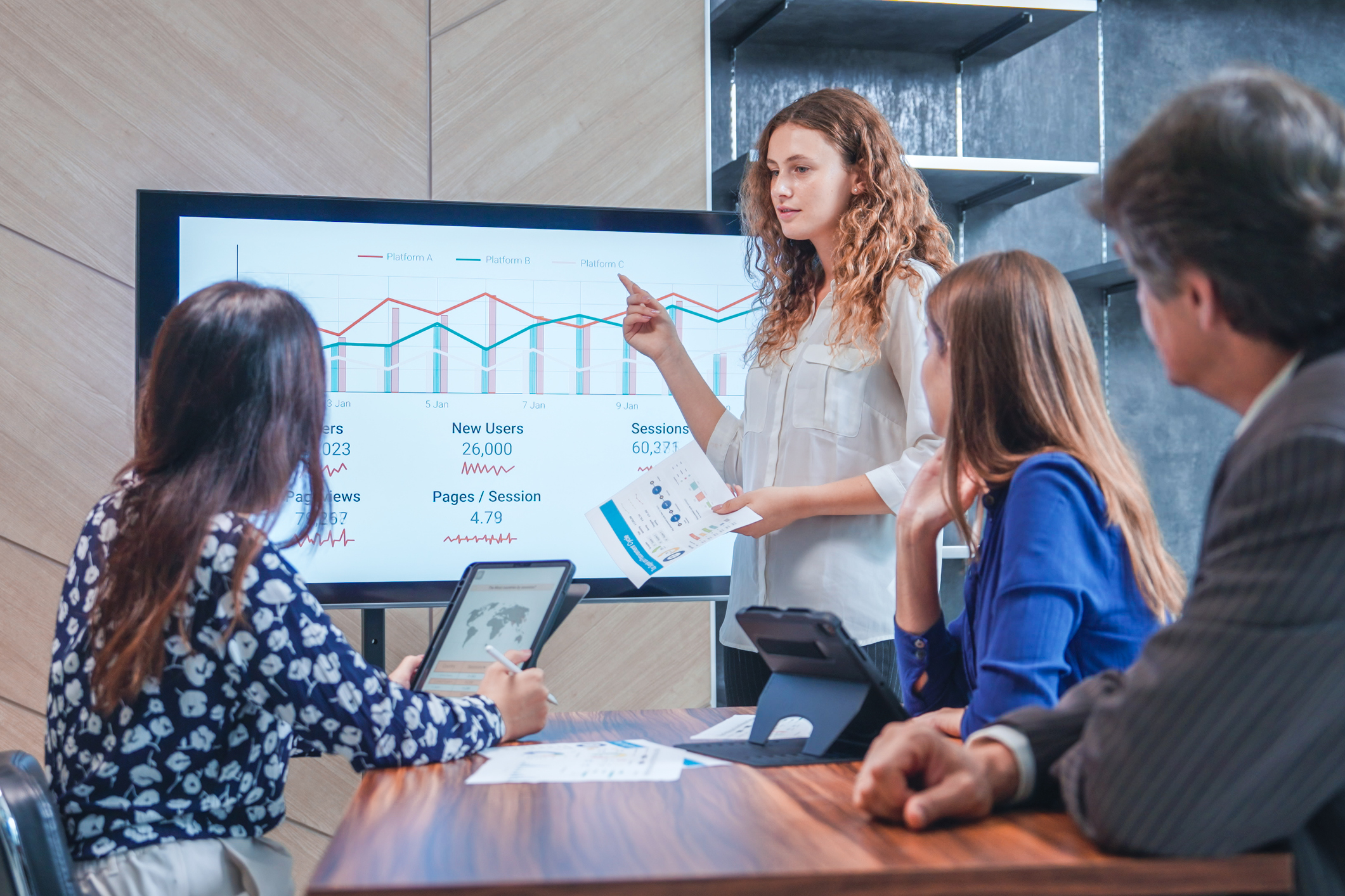 woman pointing at screen presenting to two people
