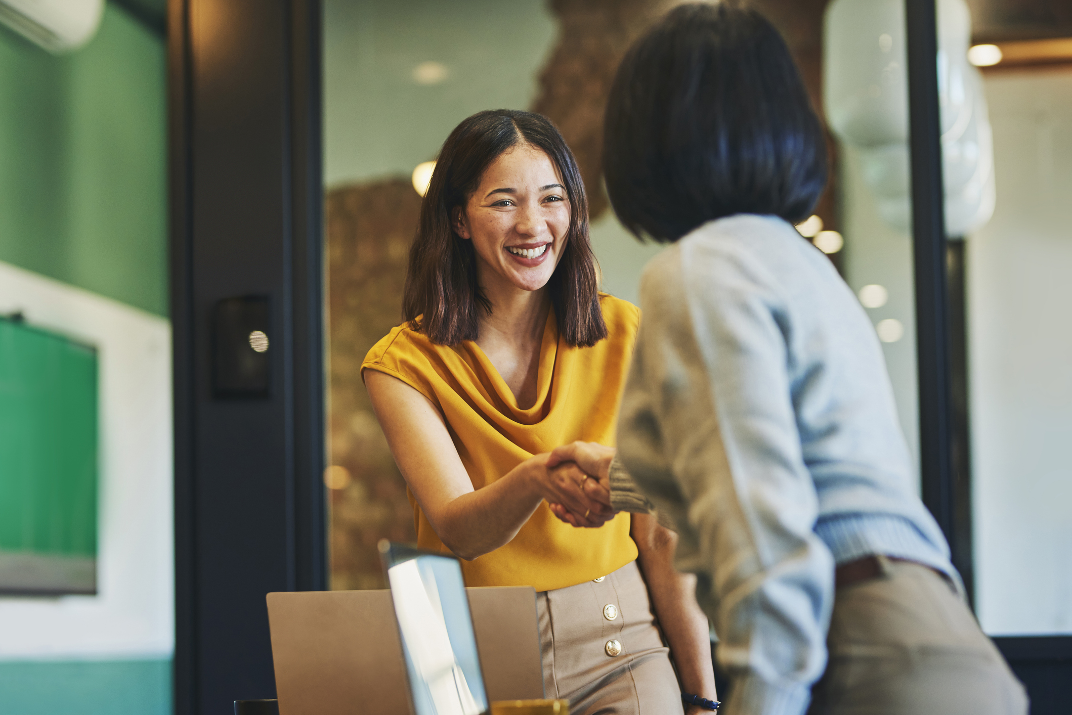 two women shaking hands