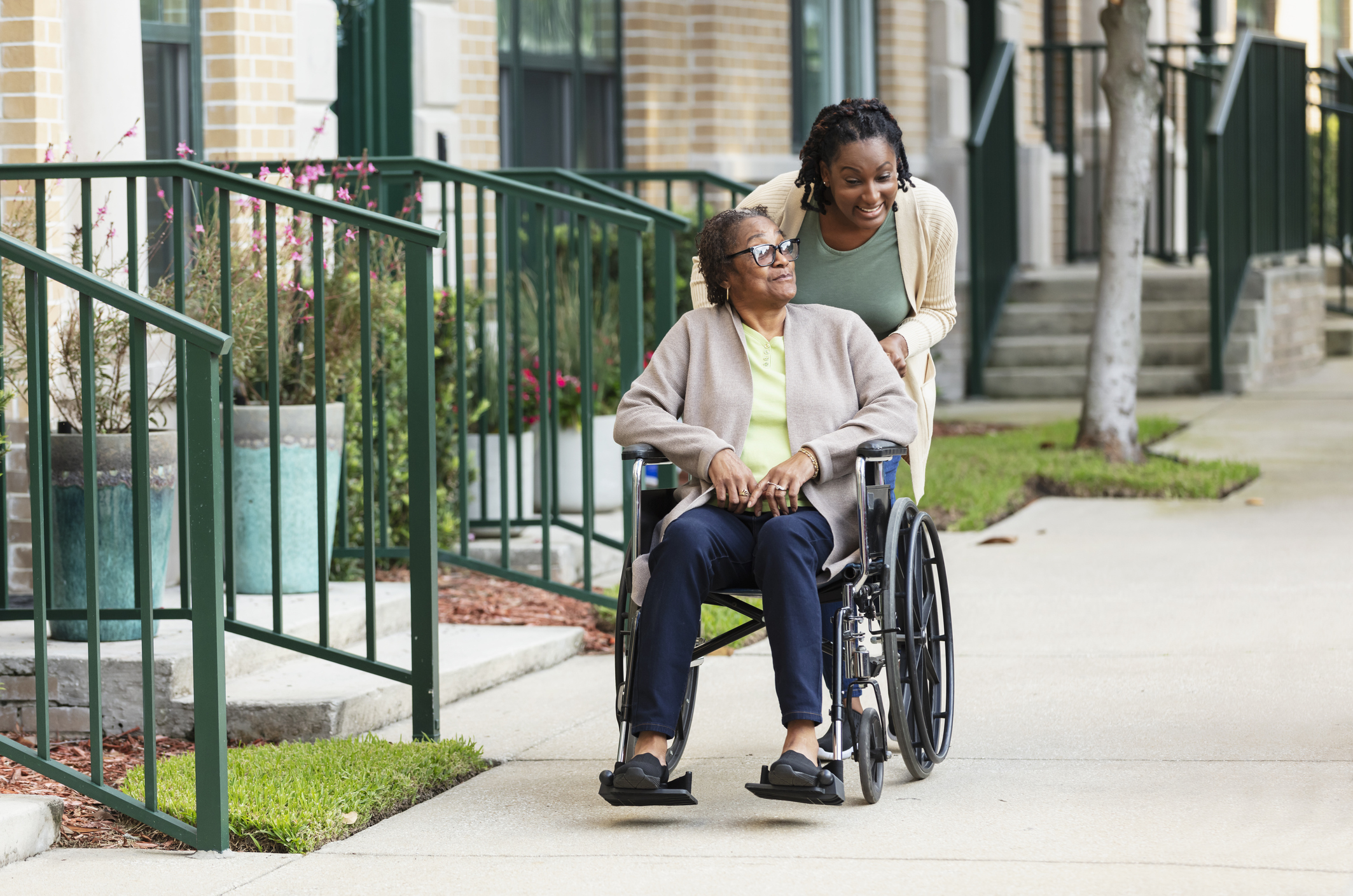 social worker pushing a person on wheelchair