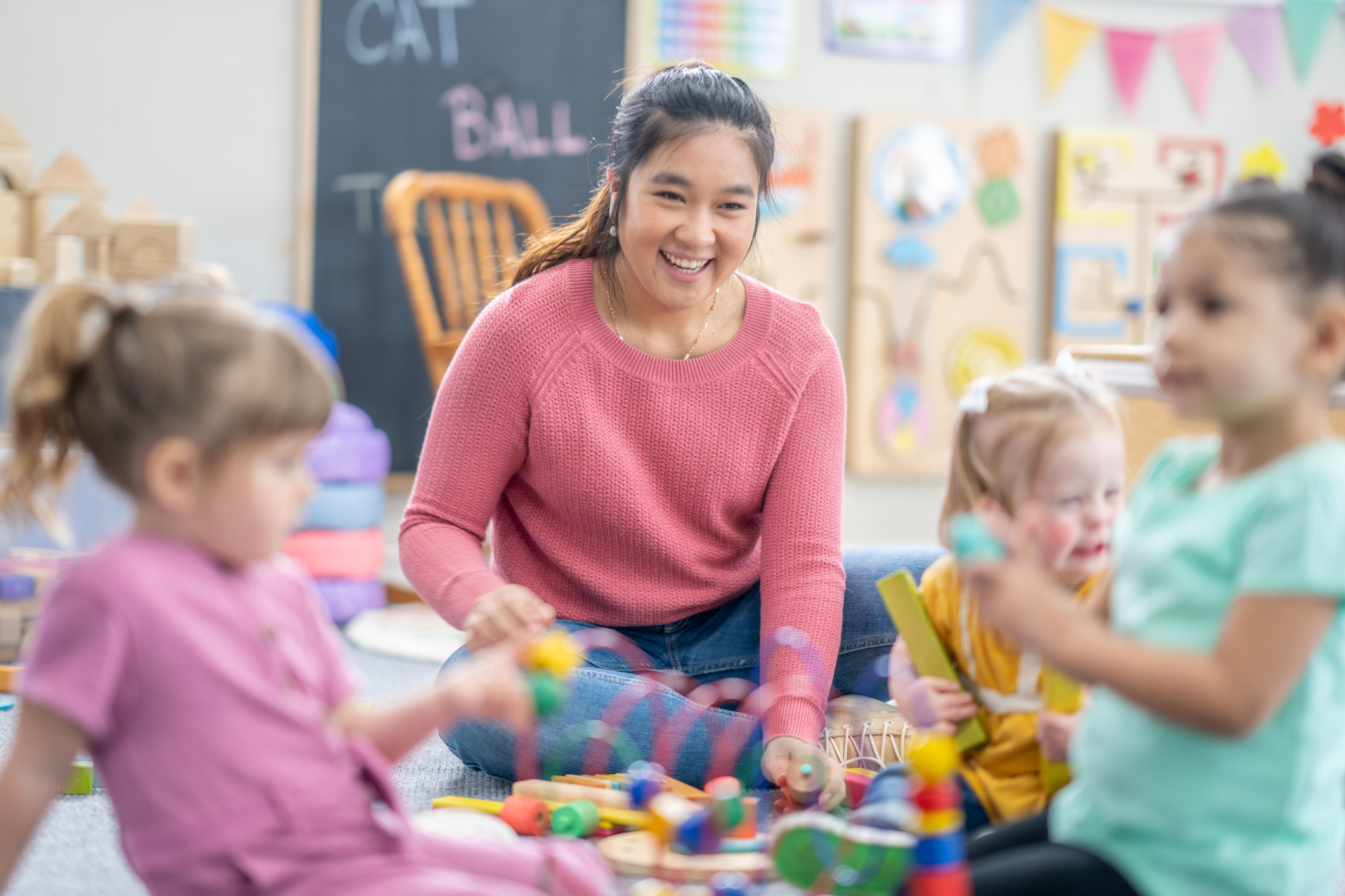 teacher playing on floor with students