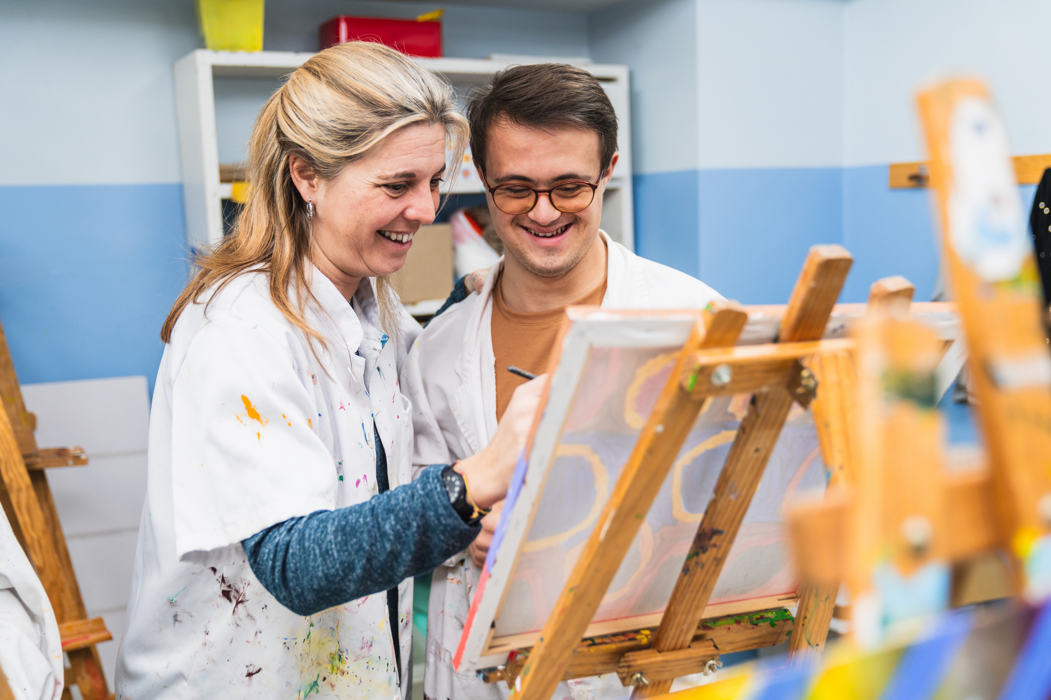 teacher helping student with painting