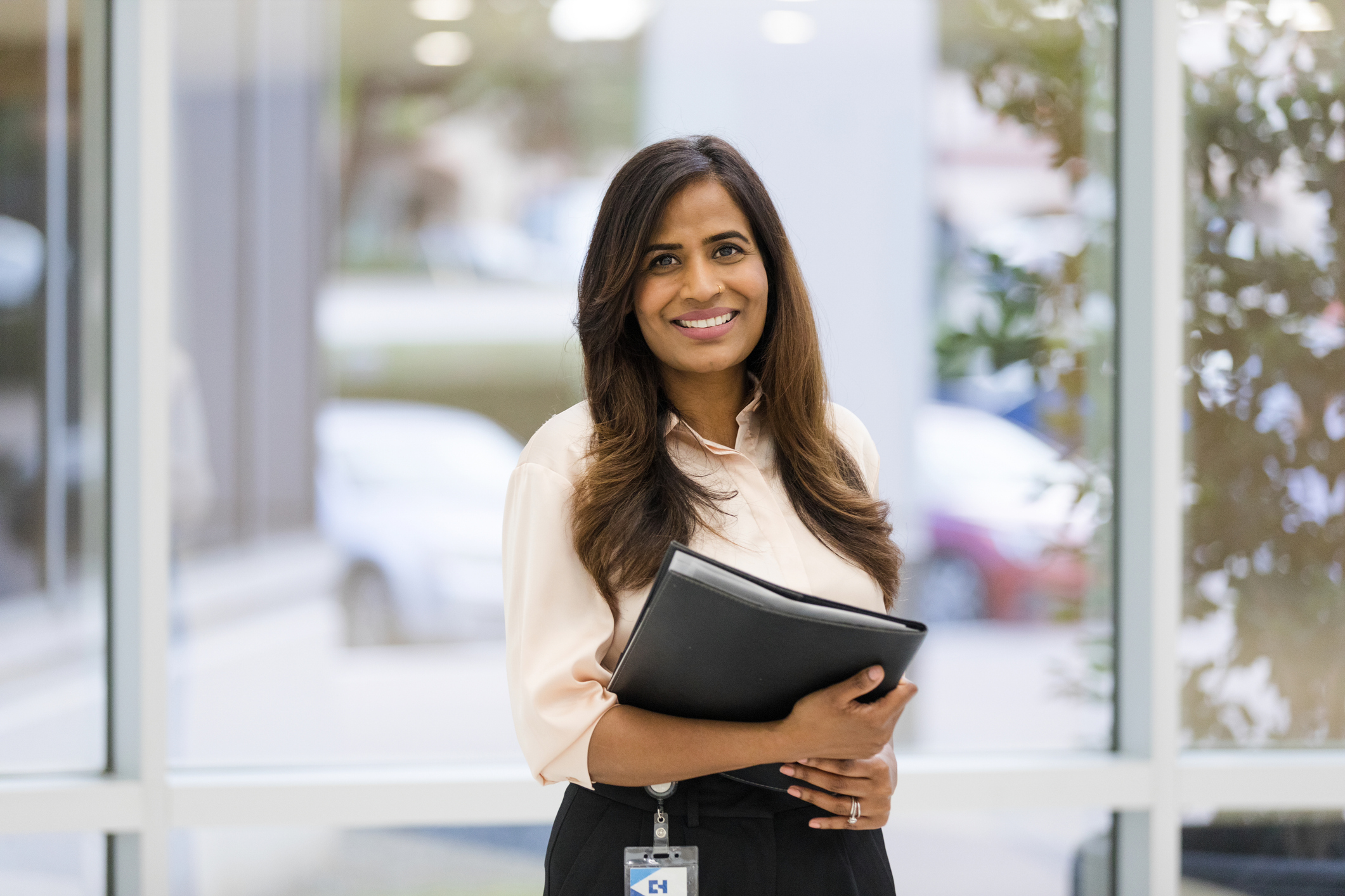 woman holding folders looking at camera