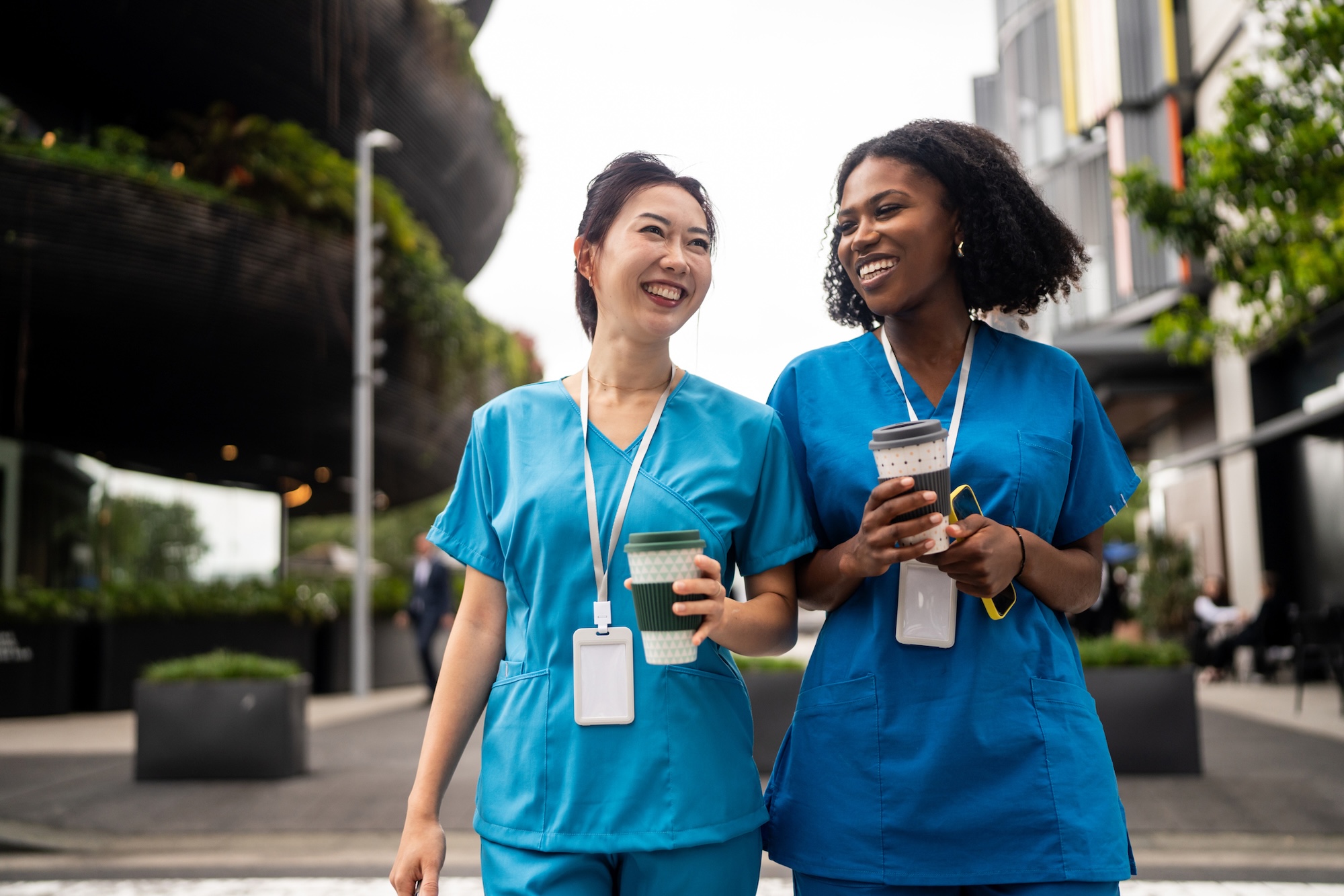 A group of women wearing scrubs holding coffee cups