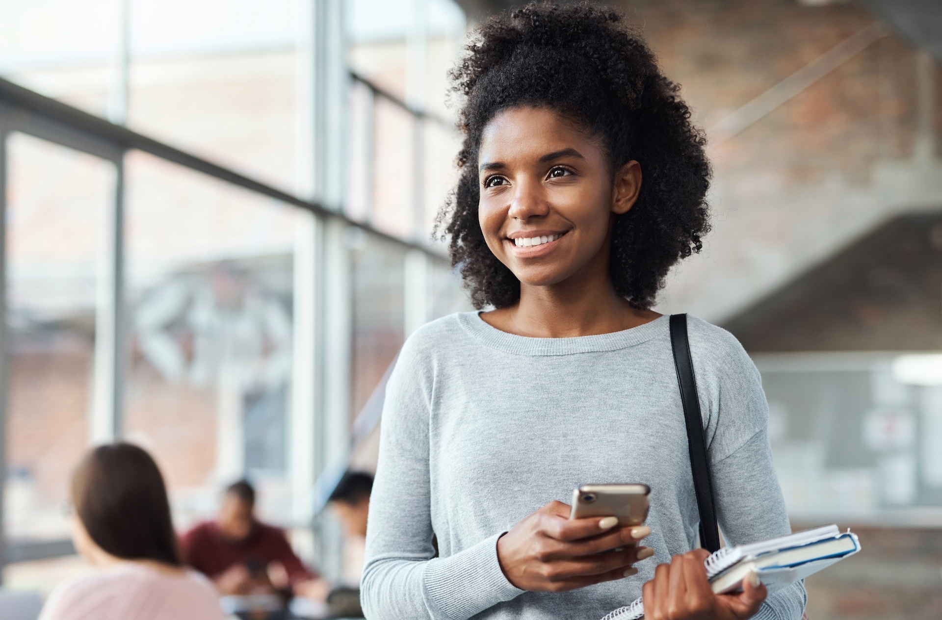 Black woman, phone or study notebook in university, college or school break on social media app or internet classroom schedule. Happy smile, education student or mobile technology and learning books