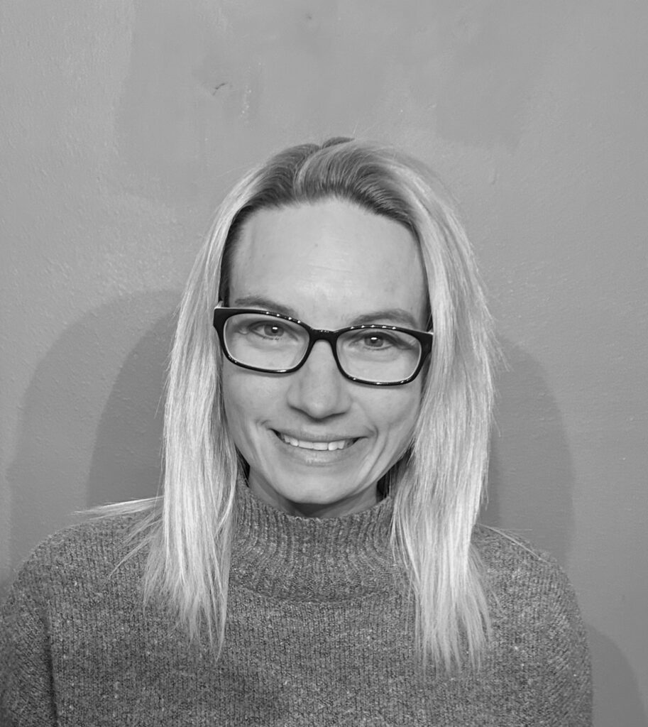 Headshot of A woman wearing glasses and a sweater