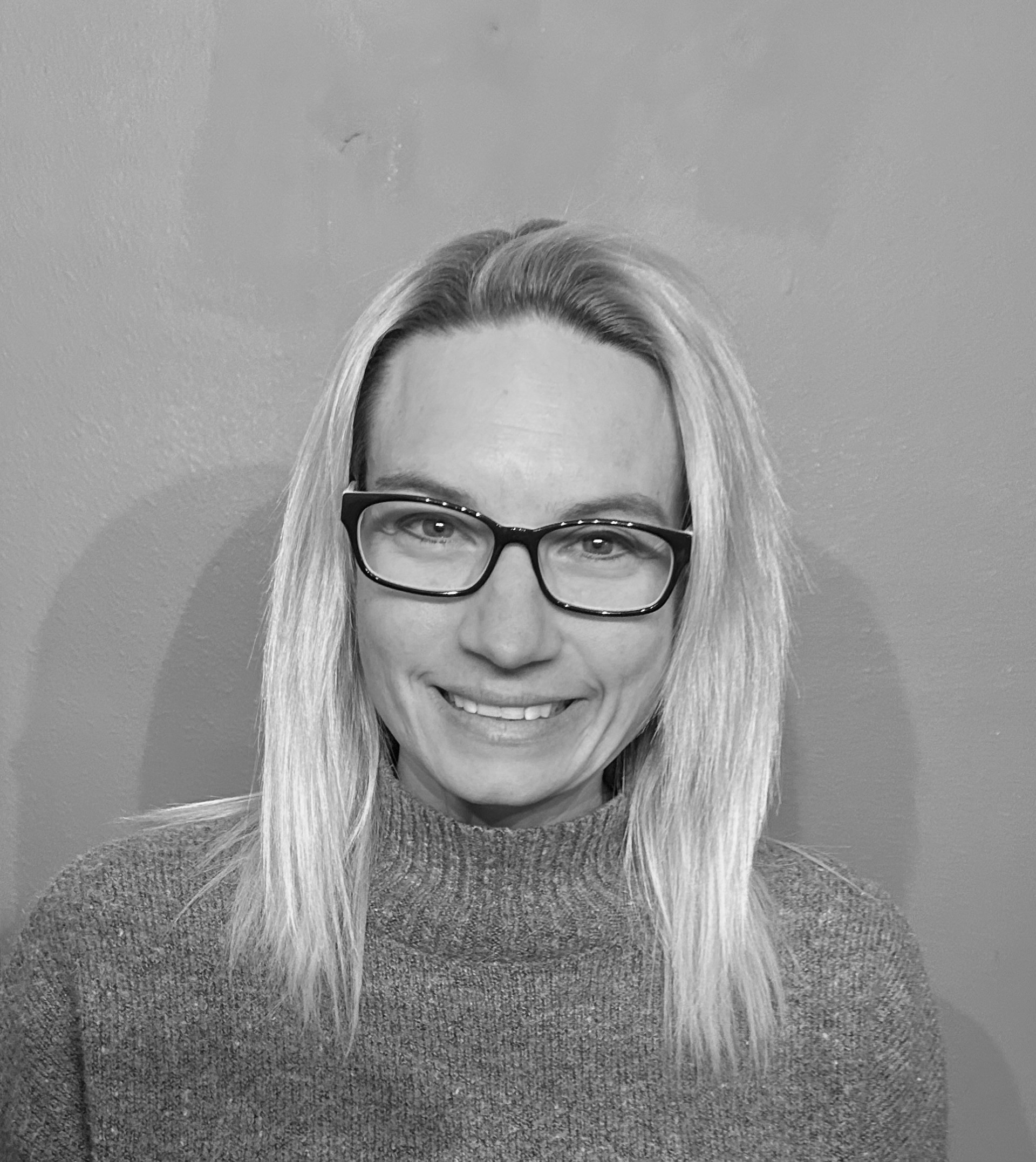 Headshot of A woman wearing glasses and a sweater